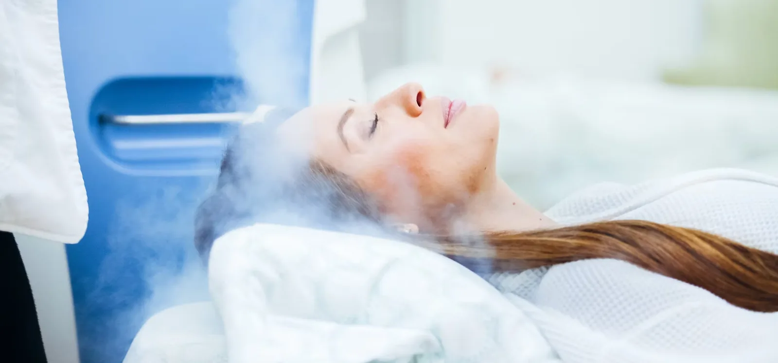 A client receiving a Cryofacial, cold vapor passing across the face
