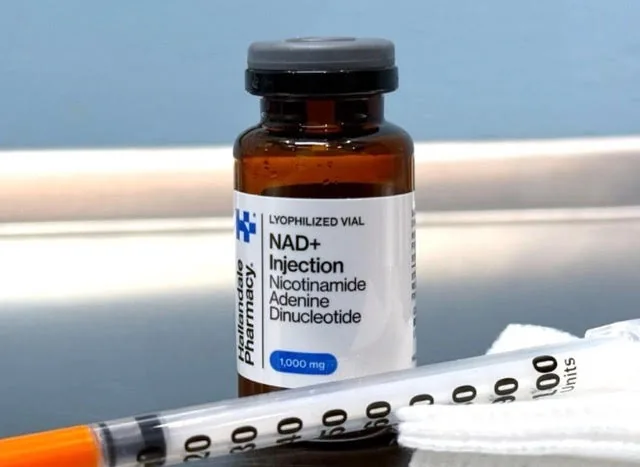 An NAD+ injection vial and syringe on a tray